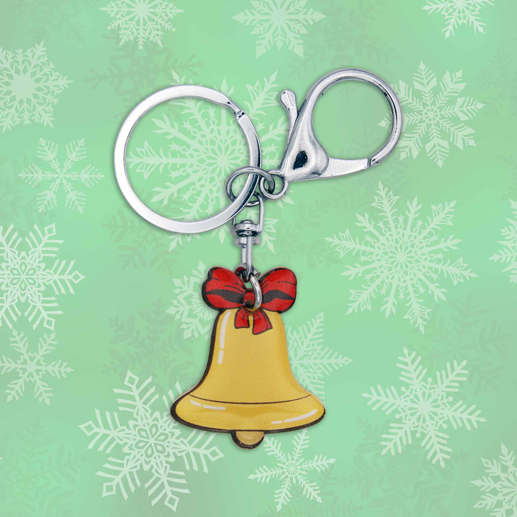 Christmas jingle bell bag charm keychain with red bow on a green snowy background.