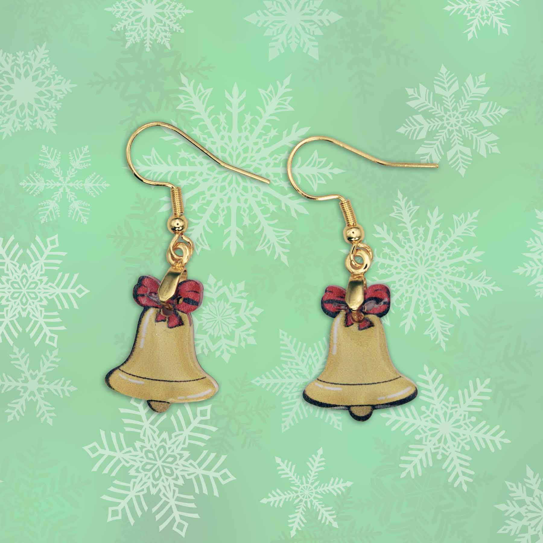 A pair of dangle earrings featuring gold-colored Christmas bell charms with red bows, against a light green background with white snowflake patterns.