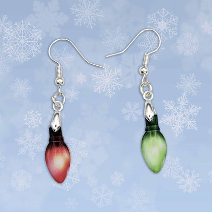 Christmas light bulb dangle earrings; one red, one green, with silver hooks, against a blue snowflake background.