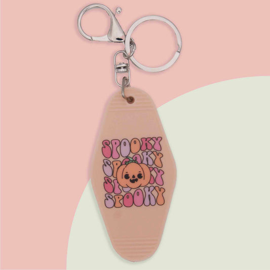 Spooky spooky spooky retro motel-style keychain with an orange jack-o'-lantern design, perfect for Halloween.