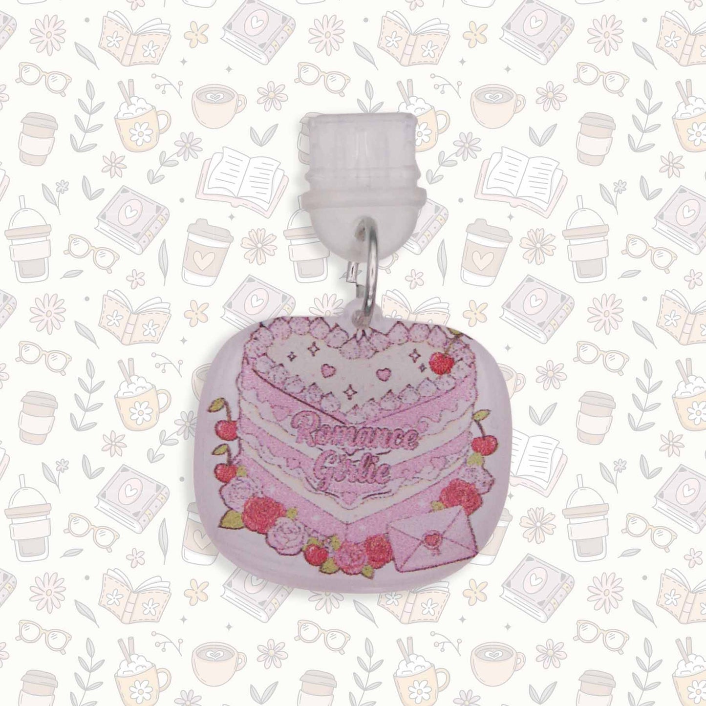 Romance Girlie Cake Kindle Charm with pink icing, cherries, and roses, on a busy pattern background