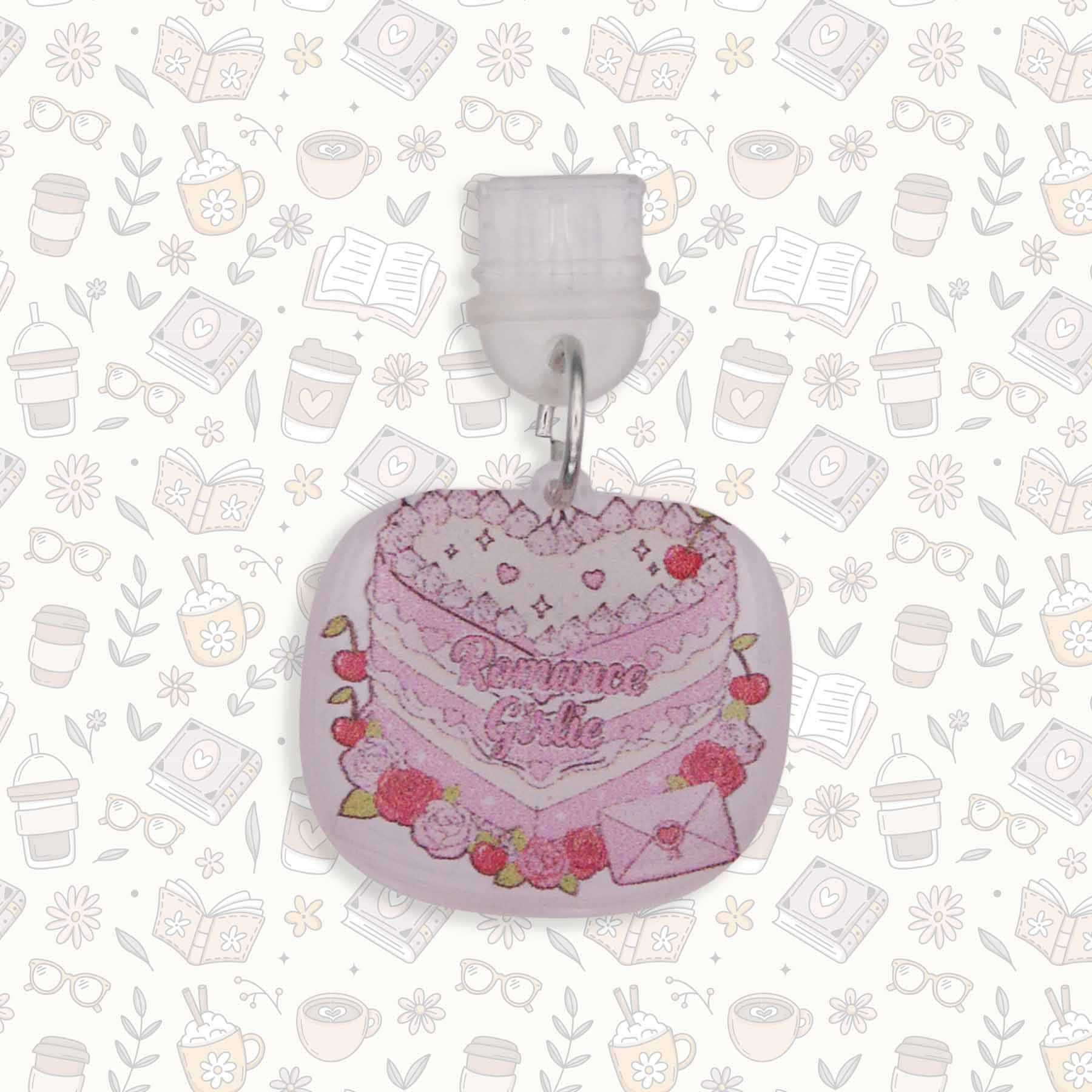 Romance Girlie Cake Kindle Charm with pink icing, cherries, and roses, on a busy pattern background