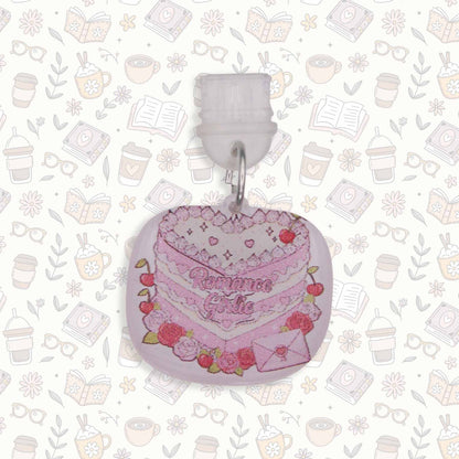 Romance Girlie Cake Kindle Charm with pink icing, cherries, and roses, on a busy pattern background
