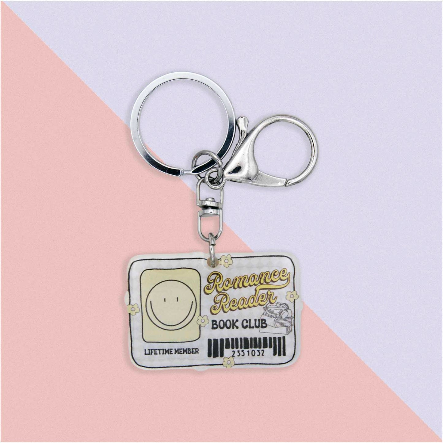 Romance Reader Book Club Lifetime Member keychain with a smiley face icon, books, and flowers, on a pink and white background.