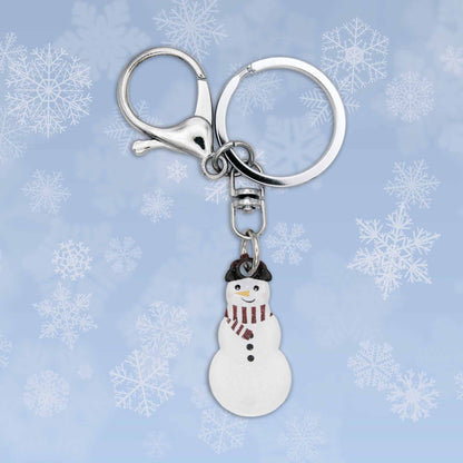 Winter snowman bag charm keychain with silver clasp and keyring against a blue snowflake background.